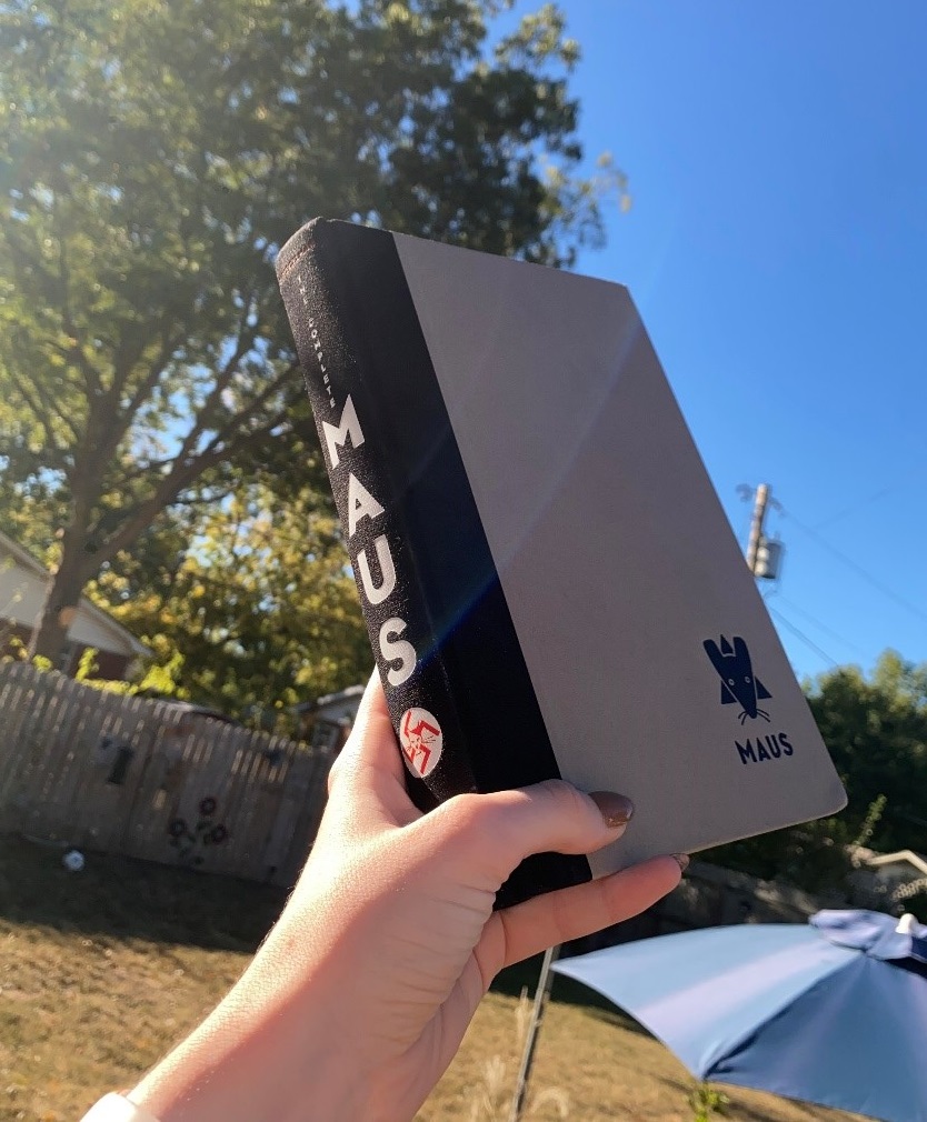 Hardcopy of Maus held up in the sky.
